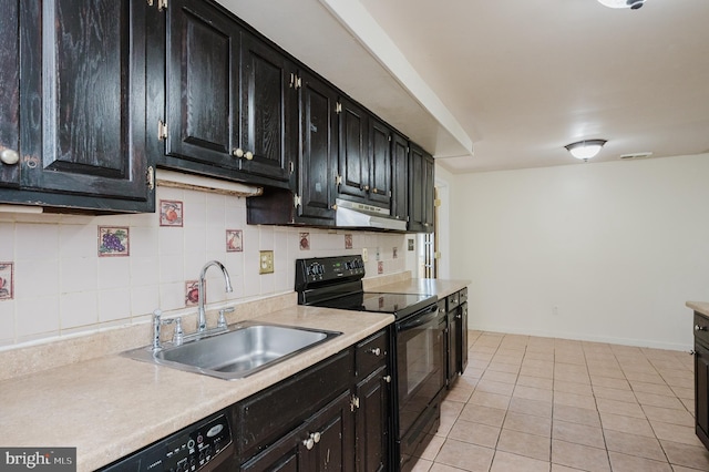 kitchen with backsplash, dark cabinets, light countertops, black appliances, and a sink