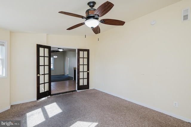 spare room featuring visible vents, a ceiling fan, french doors, carpet flooring, and baseboards