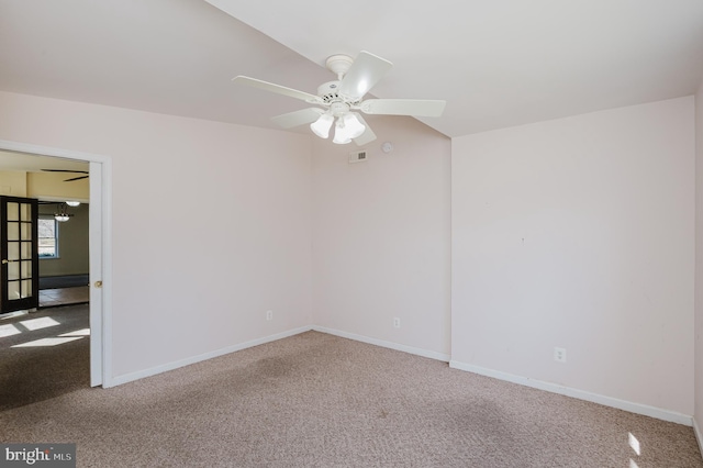 carpeted empty room featuring visible vents, a ceiling fan, and baseboards