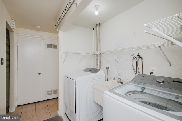 laundry room featuring light tile patterned floors, visible vents, independent washer and dryer, and laundry area