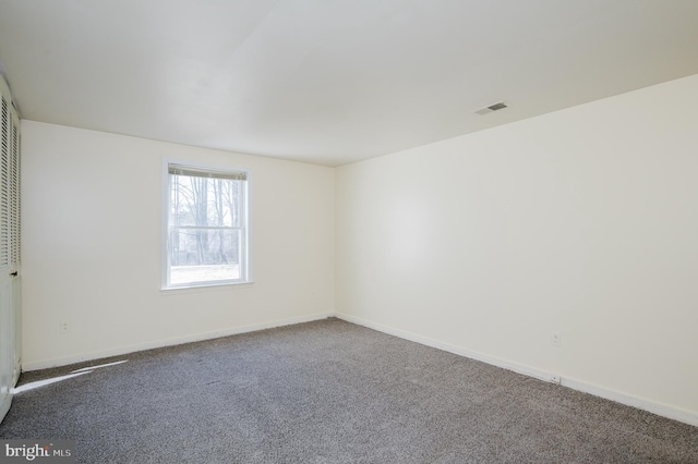 carpeted empty room with visible vents and baseboards