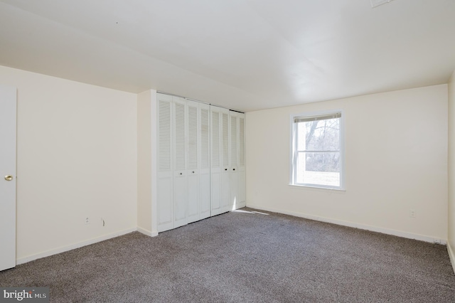 unfurnished bedroom with carpet, baseboards, and a closet