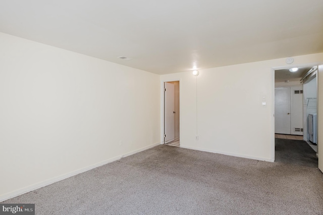 spare room featuring baseboards and carpet