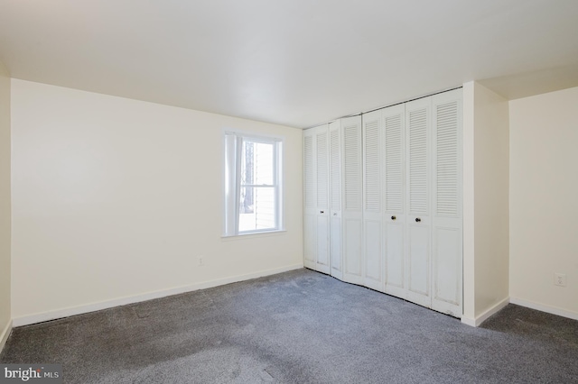 unfurnished bedroom featuring a closet, baseboards, and carpet