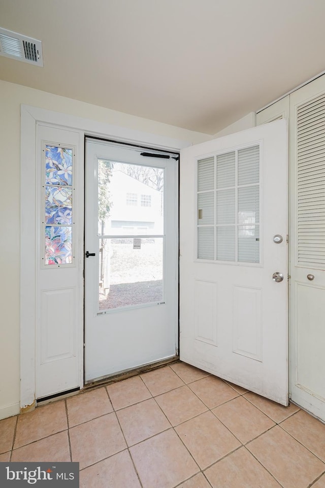 doorway to outside featuring light tile patterned floors and visible vents