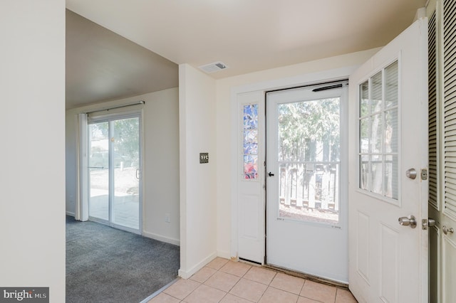 entrance foyer with light tile patterned floors, visible vents, baseboards, and light colored carpet