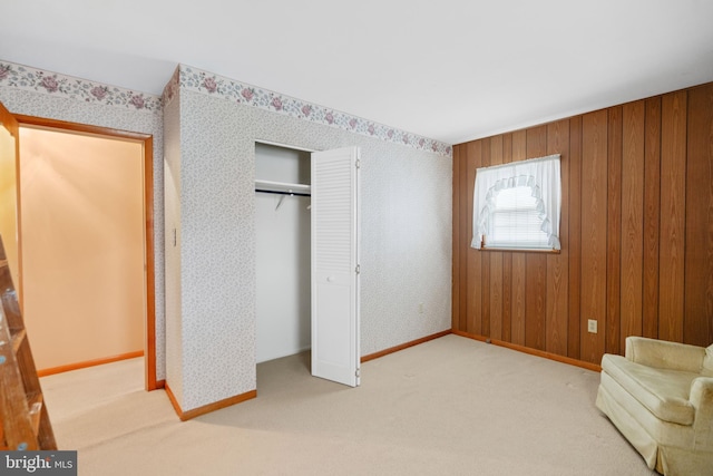 interior space with carpet, baseboards, and wallpapered walls