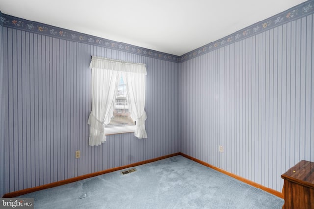 unfurnished room with wallpapered walls, baseboards, visible vents, and carpet flooring