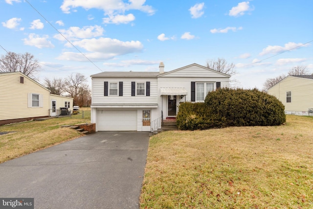 view of front of property featuring a garage, a front yard, and driveway