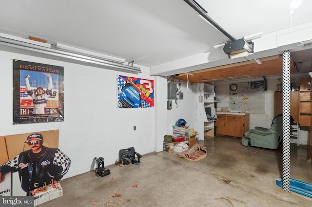 garage featuring concrete block wall and a garage door opener