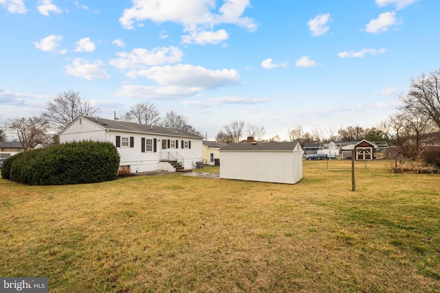 rear view of property featuring a yard, an outdoor structure, and a storage shed