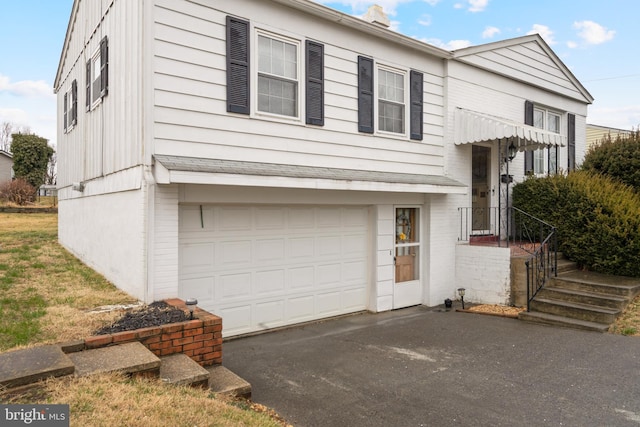 view of front of home featuring a garage and aphalt driveway