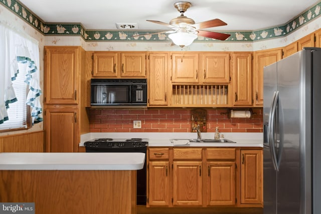 kitchen featuring a ceiling fan, light countertops, black microwave, stainless steel refrigerator with ice dispenser, and a sink