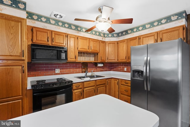 kitchen featuring a sink, black appliances, brown cabinetry, and light countertops