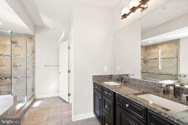 full bathroom featuring a shower stall, double vanity, tile patterned floors, and a sink