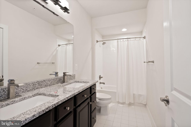 full bath with tile patterned flooring, double vanity, toilet, and a sink