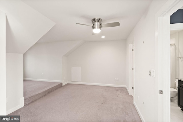 bonus room featuring baseboards, light carpet, and a ceiling fan