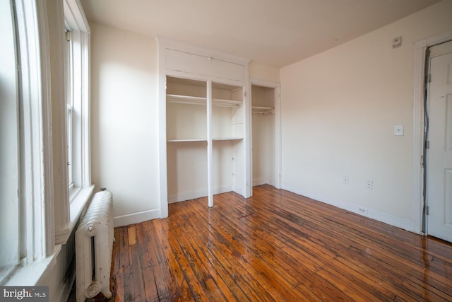 unfurnished bedroom with radiator, baseboards, and hardwood / wood-style floors