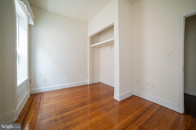 unfurnished bedroom featuring baseboards and hardwood / wood-style floors