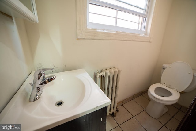 bathroom featuring toilet, tile patterned floors, vanity, and radiator