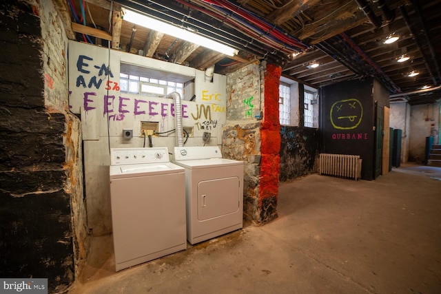 basement with a healthy amount of sunlight, radiator heating unit, and washer and clothes dryer