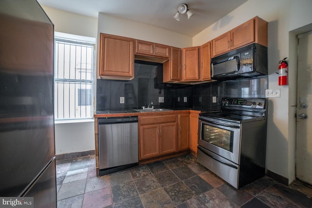 kitchen featuring stainless steel appliances, tasteful backsplash, a sink, and brown cabinets