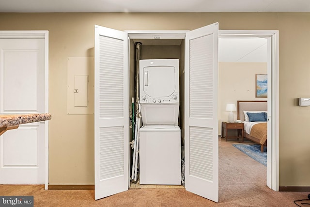 laundry room featuring laundry area, light colored carpet, electric panel, and stacked washing maching and dryer