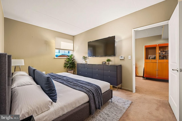 bedroom featuring baseboards and light colored carpet