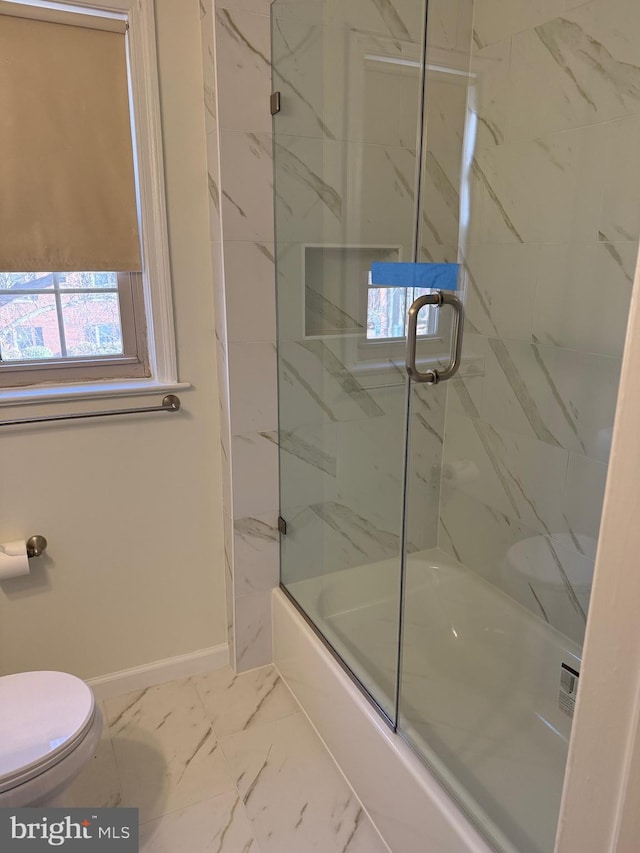 full bathroom with marble finish floor, toilet, baseboards, and bath / shower combo with glass door