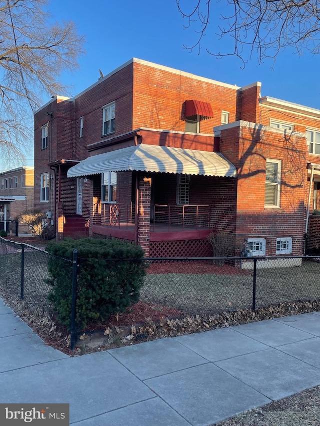 view of front of property with a fenced front yard and brick siding