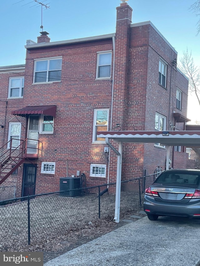 exterior space with brick siding, a chimney, and fence private yard