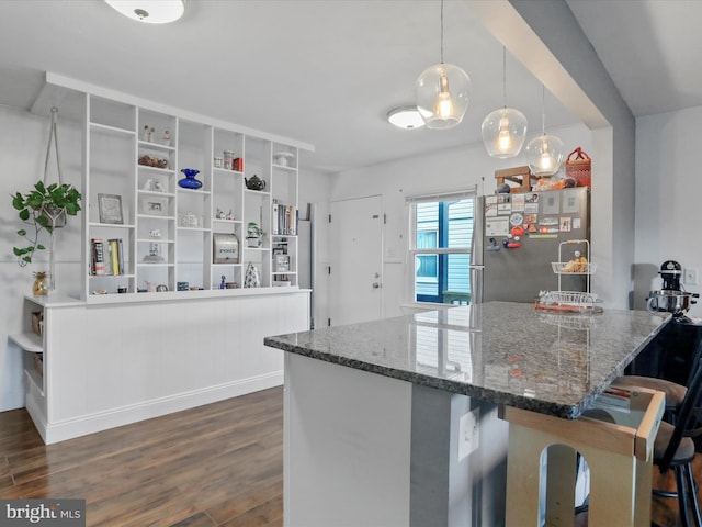 kitchen featuring a breakfast bar area, stone countertops, freestanding refrigerator, dark wood-style floors, and open shelves