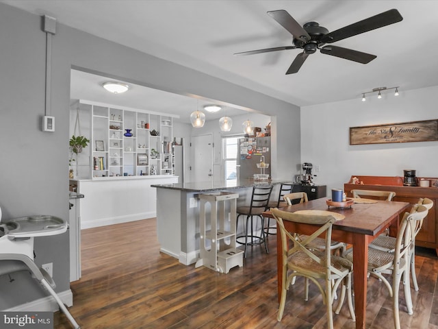 dining room featuring ceiling fan, baseboards, and wood finished floors