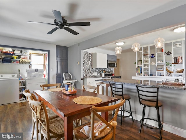 dining room with dark wood-style floors, a ceiling fan, and washer and dryer