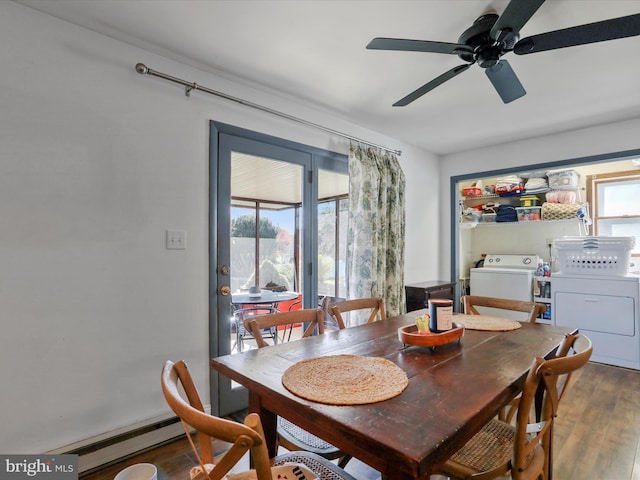 dining room featuring ceiling fan, baseboard heating, wood finished floors, and independent washer and dryer