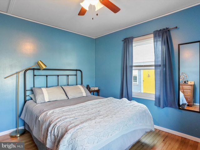 bedroom featuring a ceiling fan, baseboards, and wood finished floors