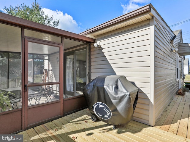 wooden deck featuring area for grilling and a sunroom