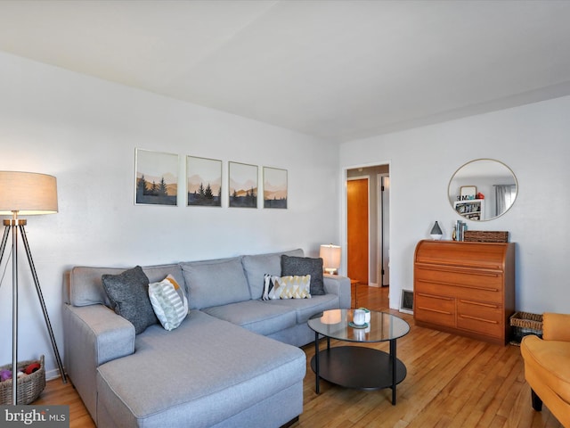 living room with light wood-style flooring and visible vents