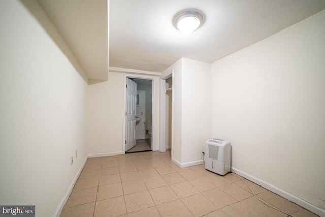 unfurnished room featuring light tile patterned floors and baseboards