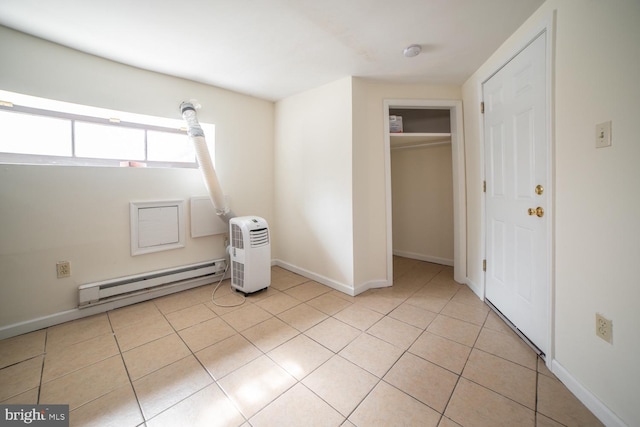 unfurnished bedroom with light tile patterned floors, baseboards, baseboard heating, and a closet