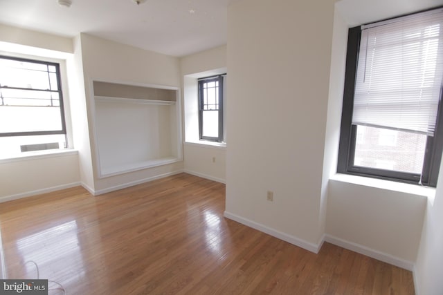 spare room featuring baseboards and wood finished floors