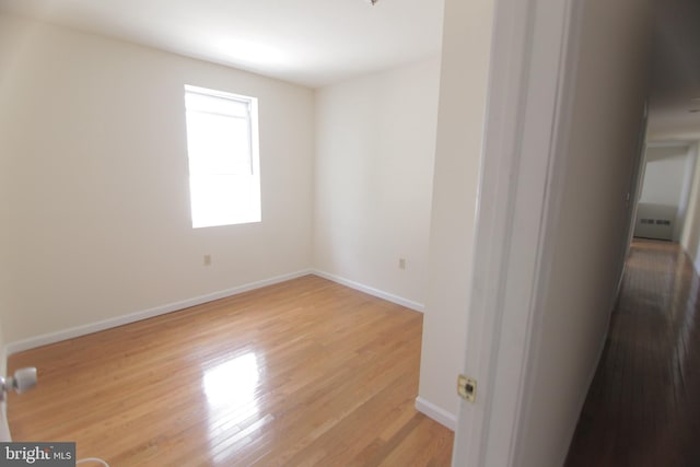 unfurnished room with baseboards and light wood finished floors