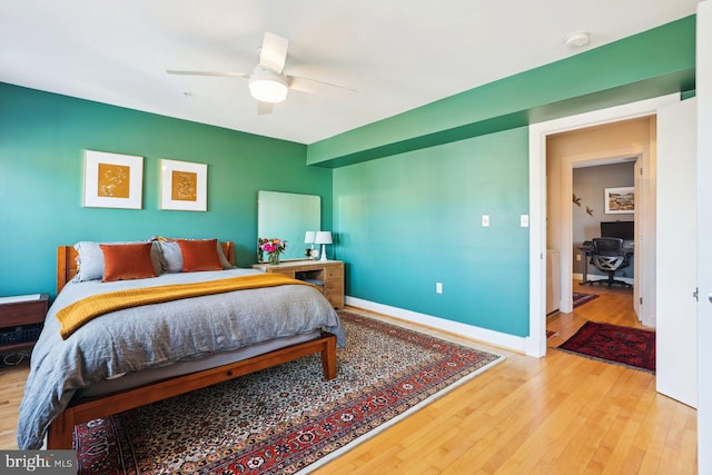 bedroom with ceiling fan, baseboards, and wood finished floors