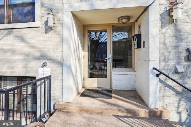 doorway to property featuring brick siding