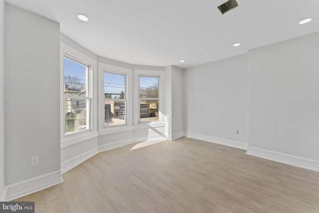 empty room featuring recessed lighting, light wood-style flooring, and baseboards