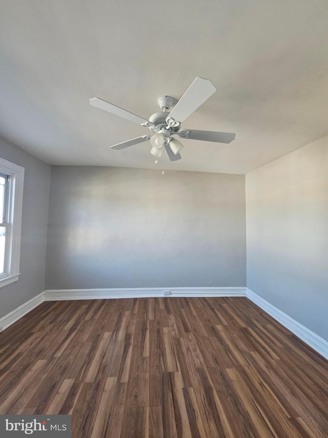 unfurnished room featuring dark wood-type flooring, baseboards, and a ceiling fan