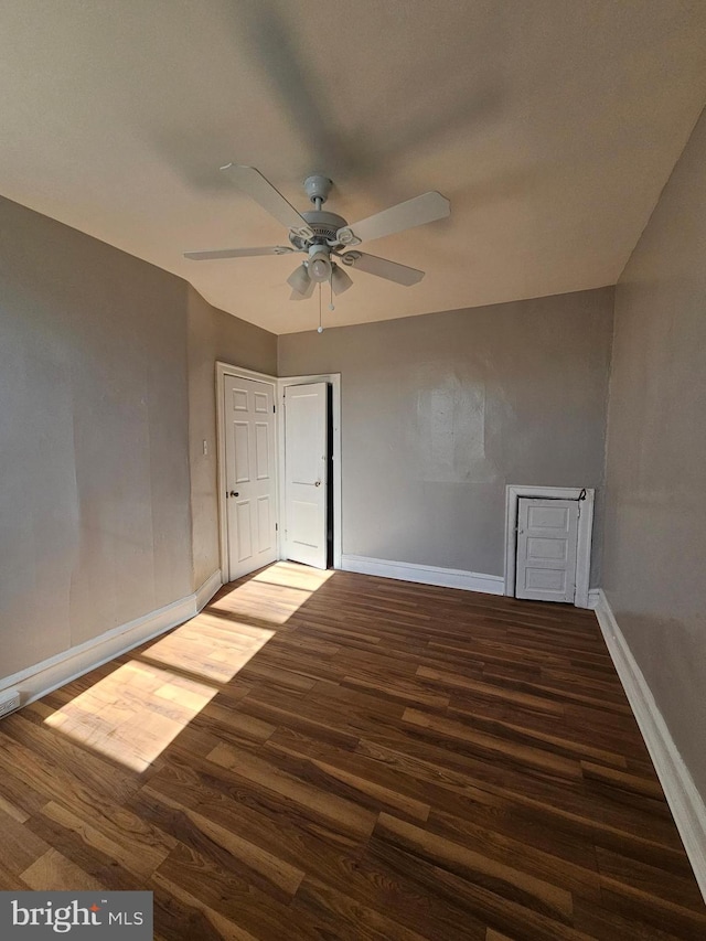 empty room featuring ceiling fan, wood finished floors, and baseboards