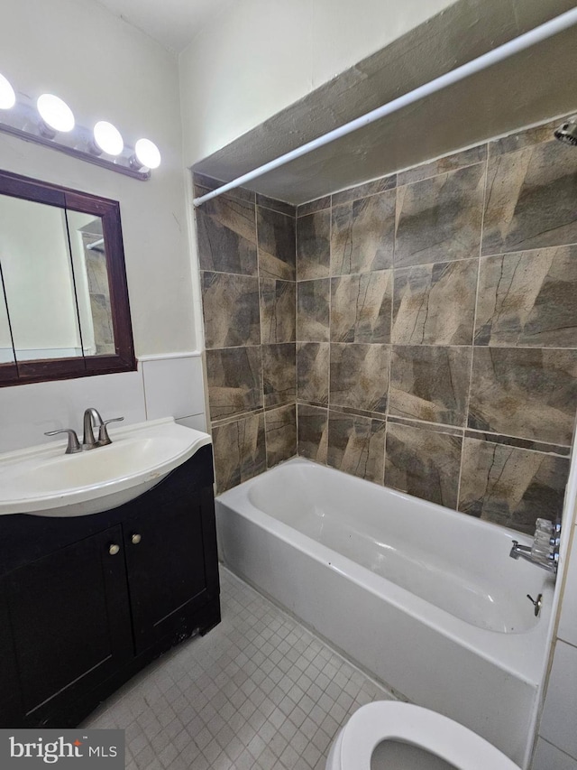 bathroom featuring tile walls, toilet, washtub / shower combination, vanity, and tile patterned flooring