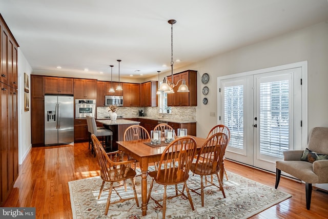 dining space featuring light wood finished floors, french doors, and recessed lighting