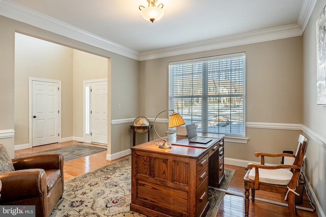 office space featuring baseboards, crown molding, and light wood-style floors